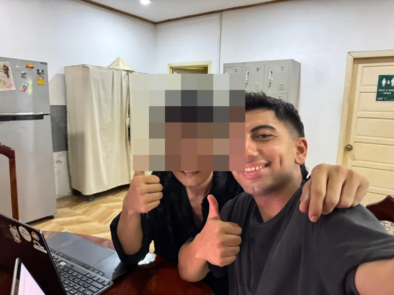 Yiğitและเพื่อนถ่ายเซลฟี่ในอาคารแล้วชูนิ้วโป้ง