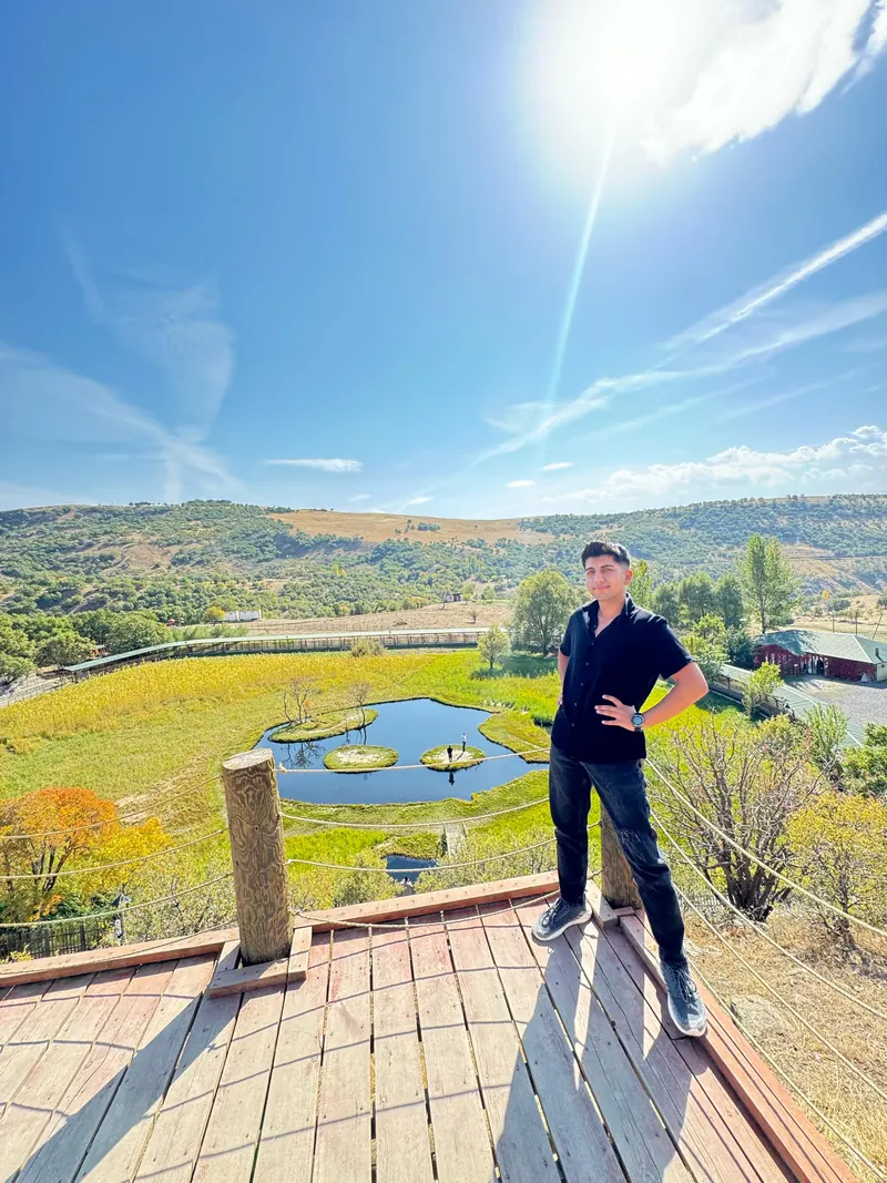 Yiğit on a wooden overlook above fields